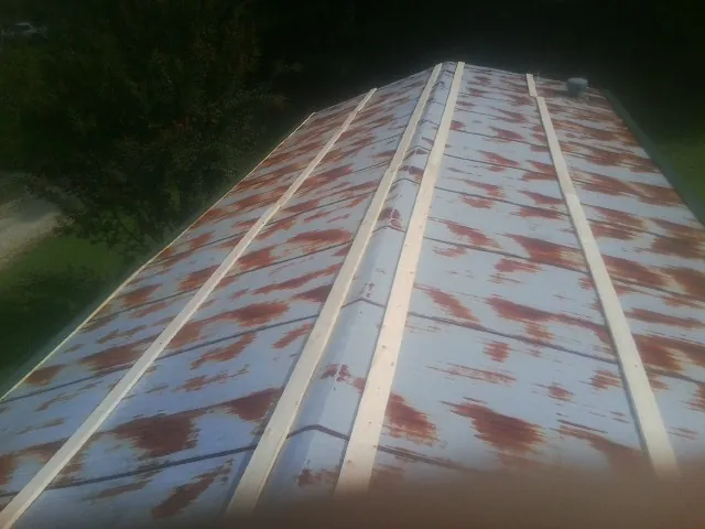 Rusted metal roof panels with new wood purlins before replacement — Storm Damage Roof Repair in Barney by Roofing Brothers