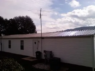 New metal roof on a single wide mobile home with a TV antenna in Barney